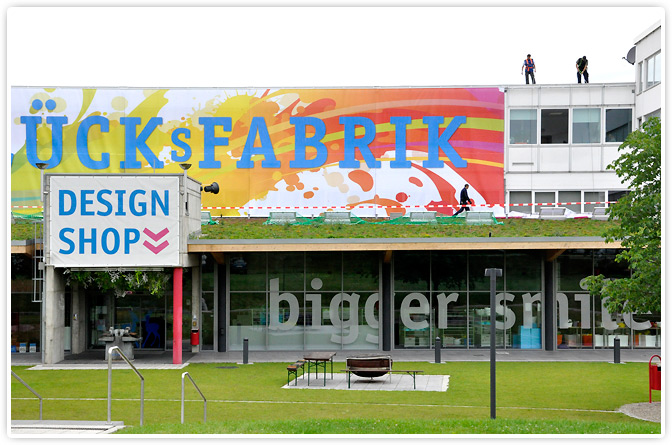 Anbringen des neuen Banners an der Fassade der Glücksfabrik.